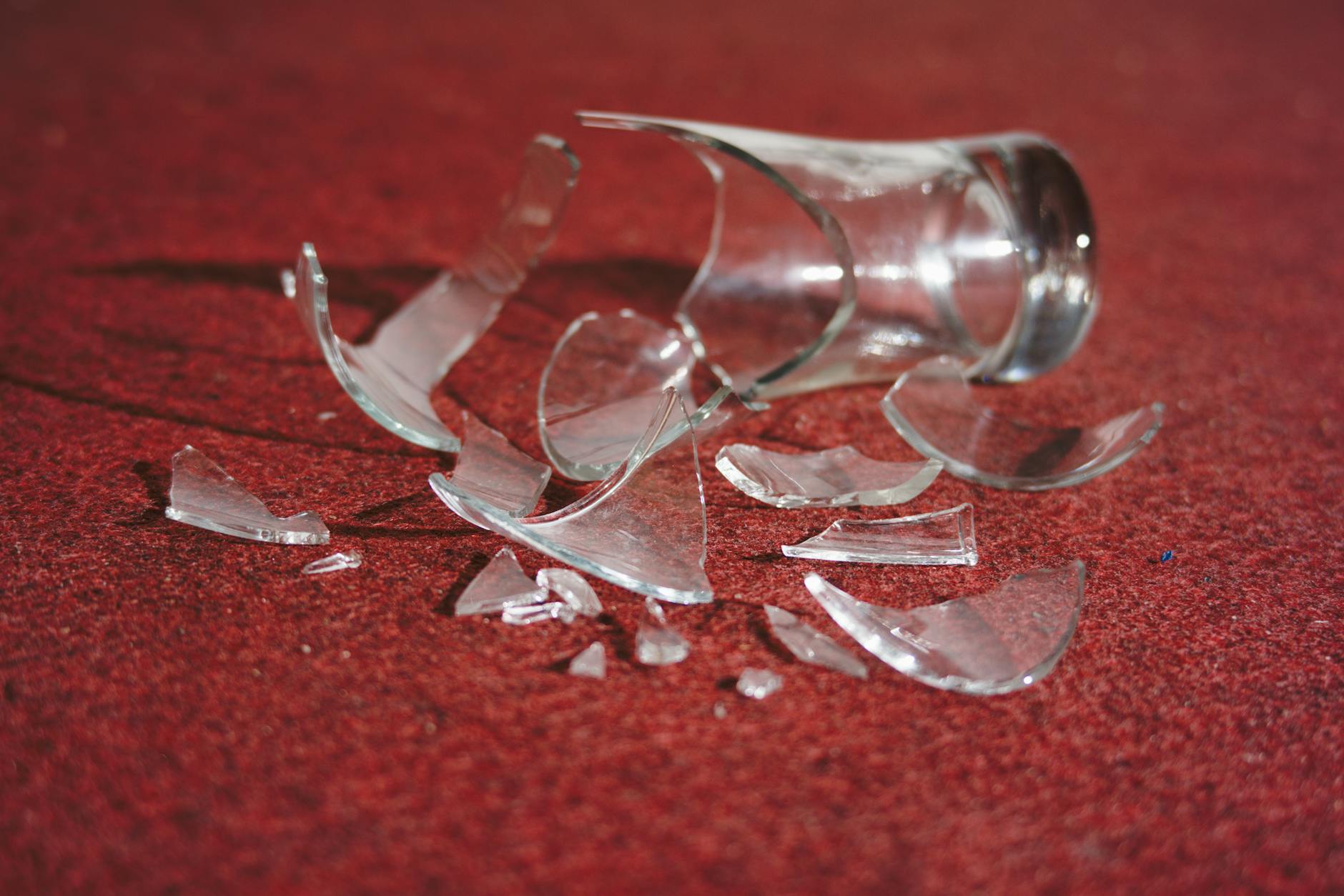 shattered glass on red carpet dramatic still life