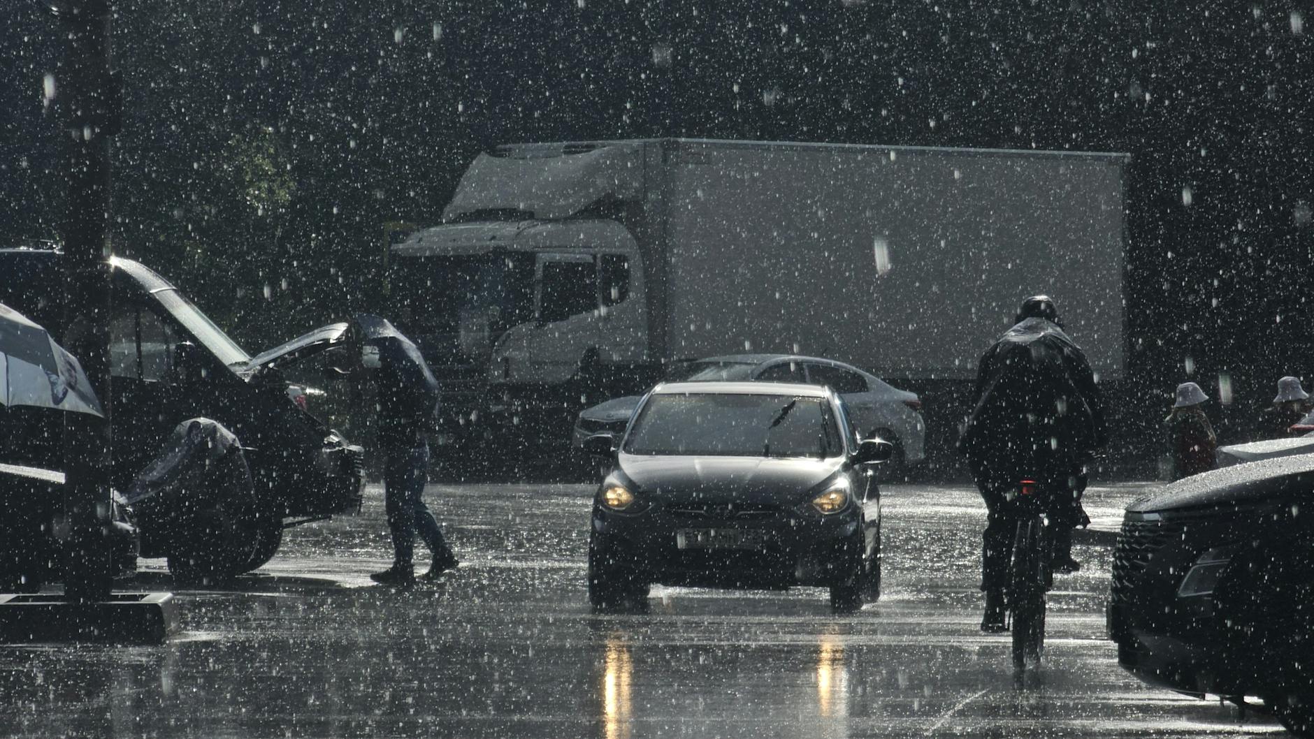 view of cars and pedestrians on the street in rain