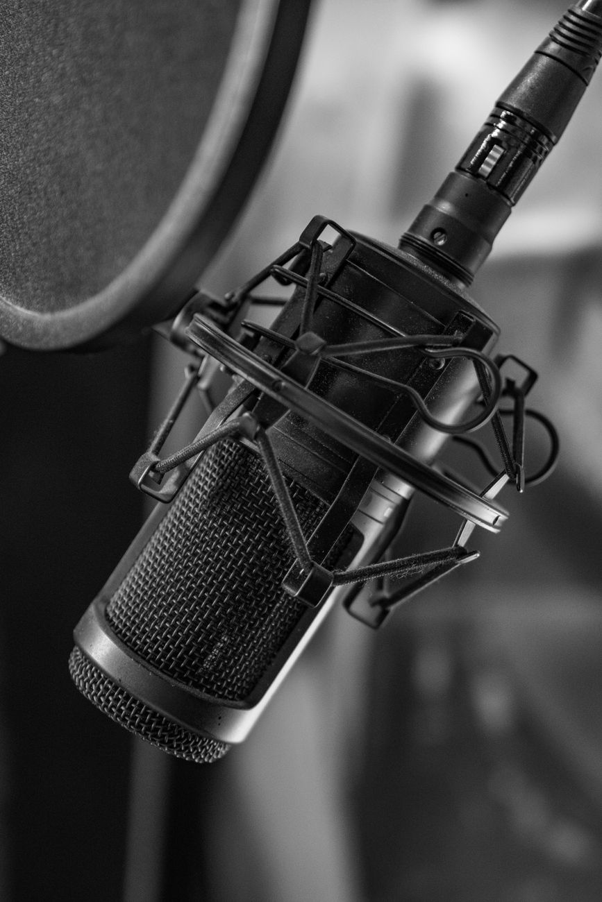 black and white photograph of microphone on microphone stand