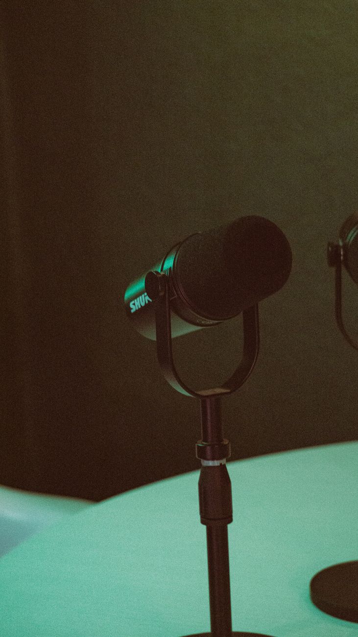 two microphones on a table with green lights
