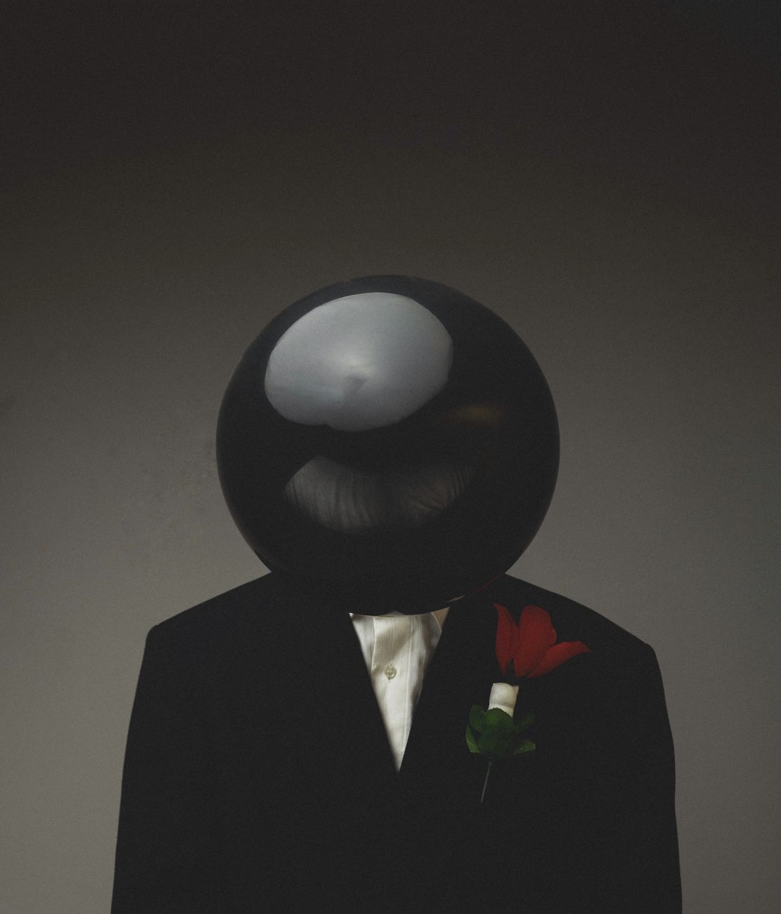 surreal portrait of suit with black sphere head